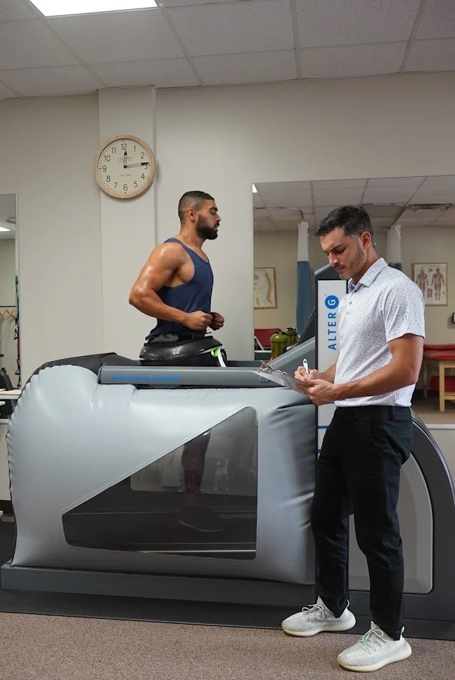 Physical therapist working with patient on AlterG anti-gravity treadmill
